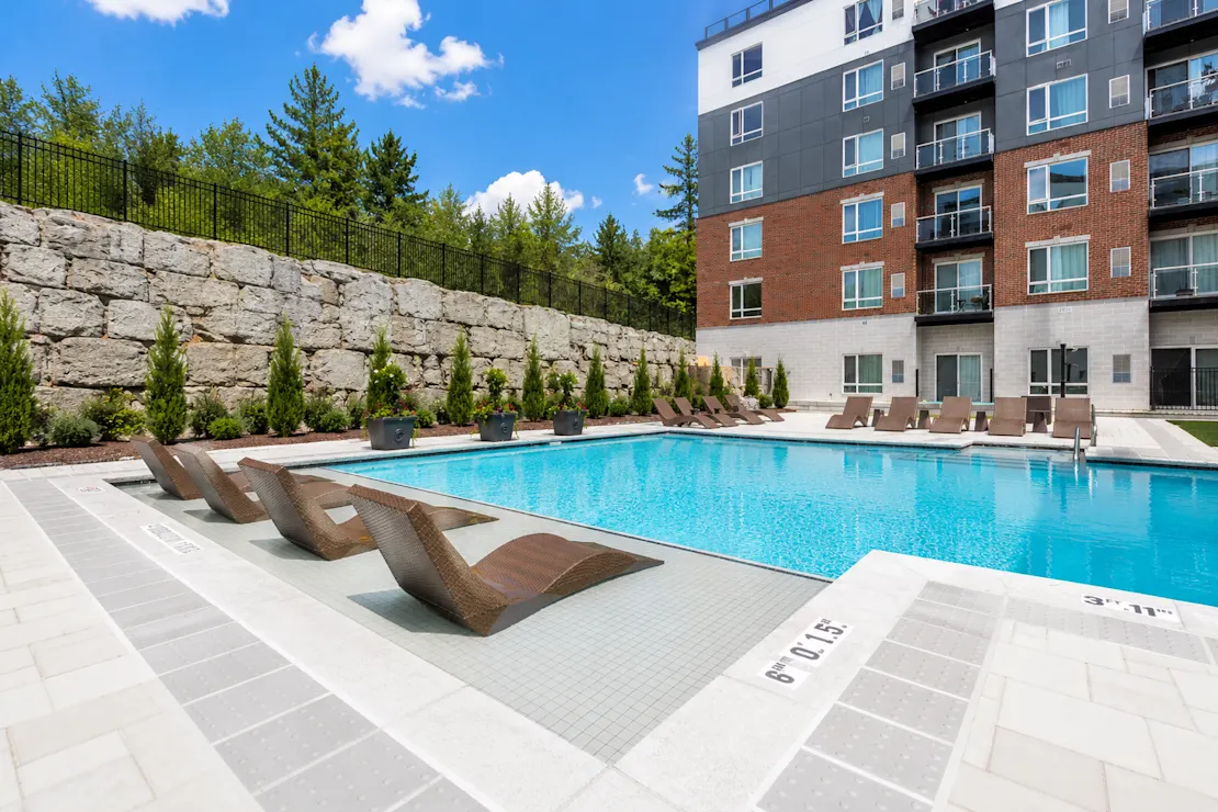 The outdoor pool with lounge chairs and the building behind