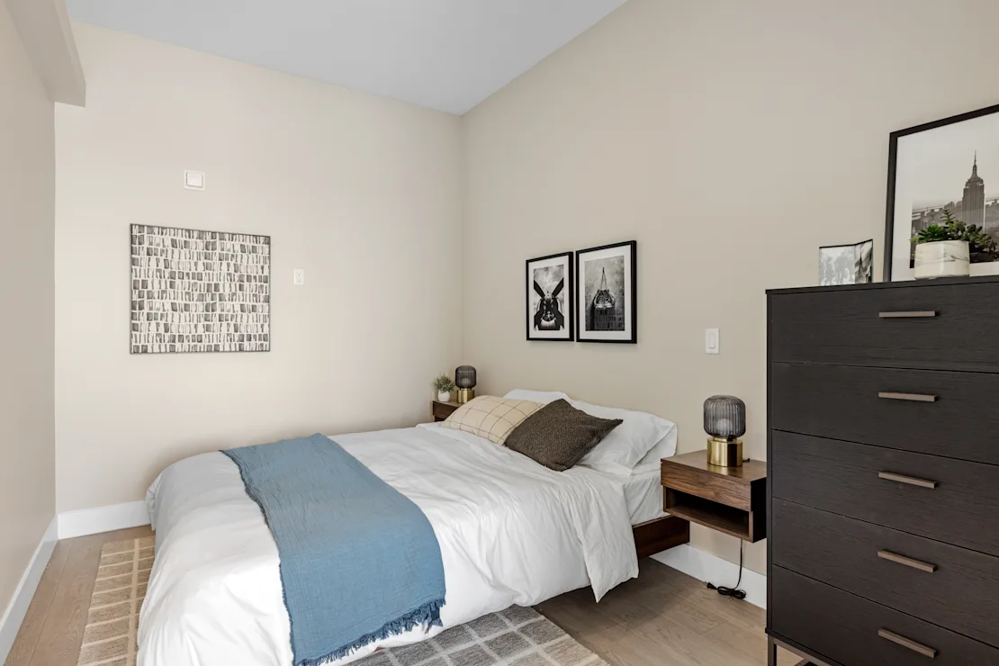 Bedroom made up in white linen with a blue throw