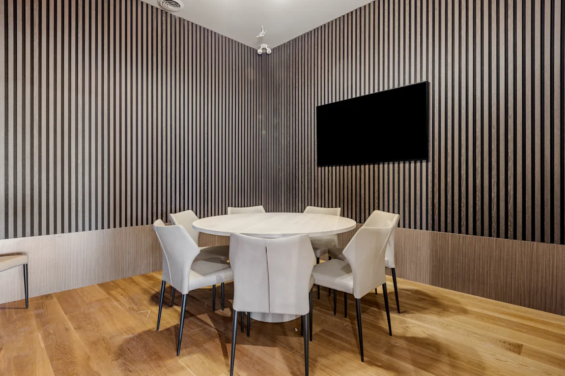 Boardroom with a white table and upholstered chairs